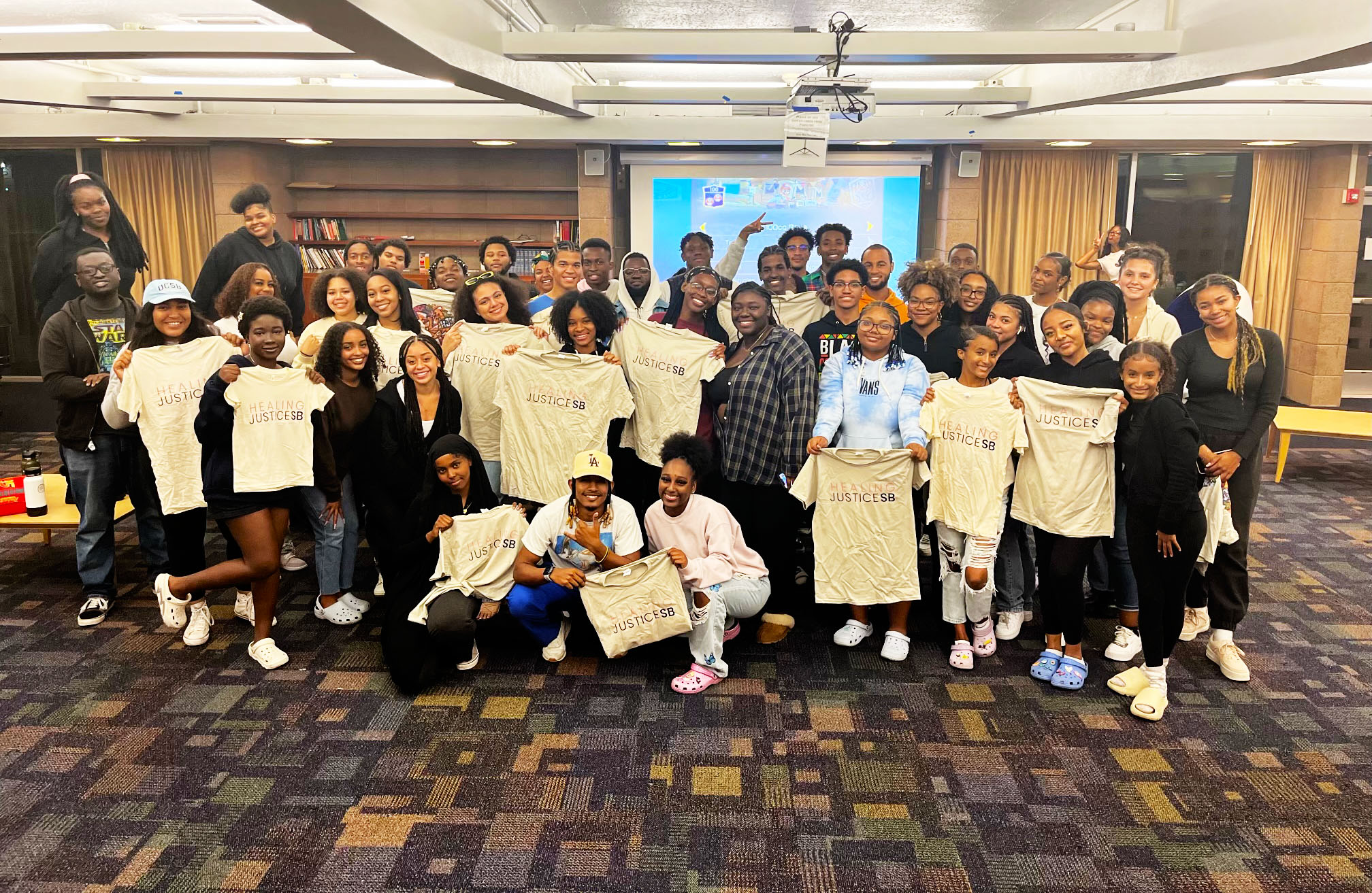 Large group of UCSB black student holding Healing Justice t-shirts