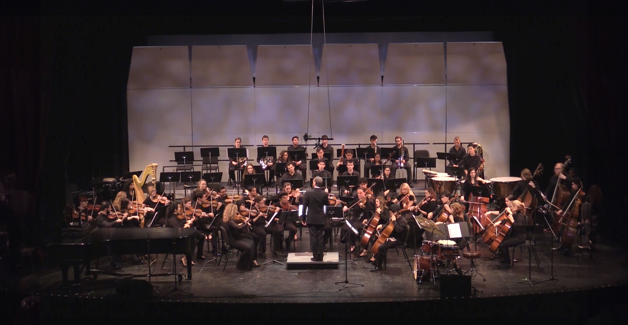 Jazz orchestra with conductor in front from back on stage at UCLA's school of musicauditorium