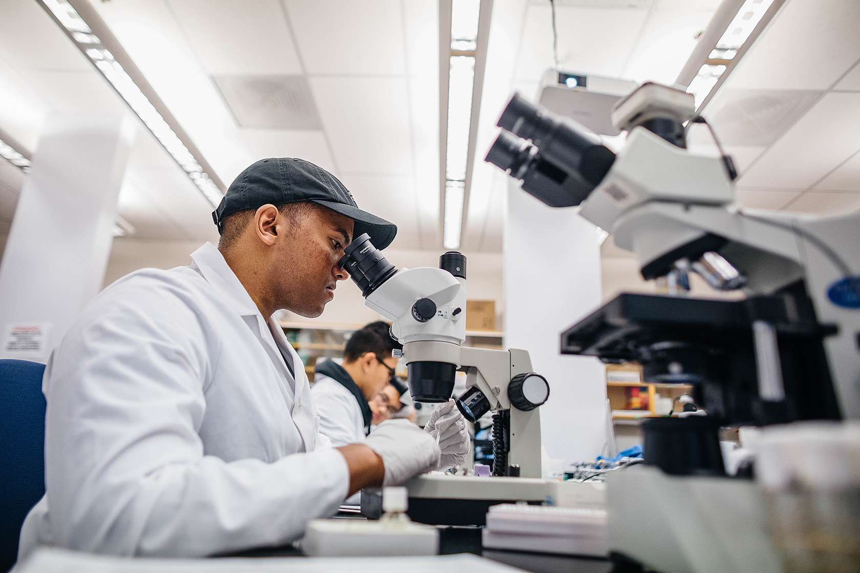 African American student at a microscope in biology lab