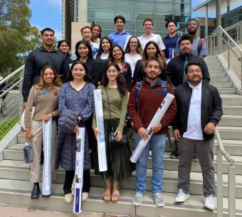 Group of 19 students posing standing on stairs