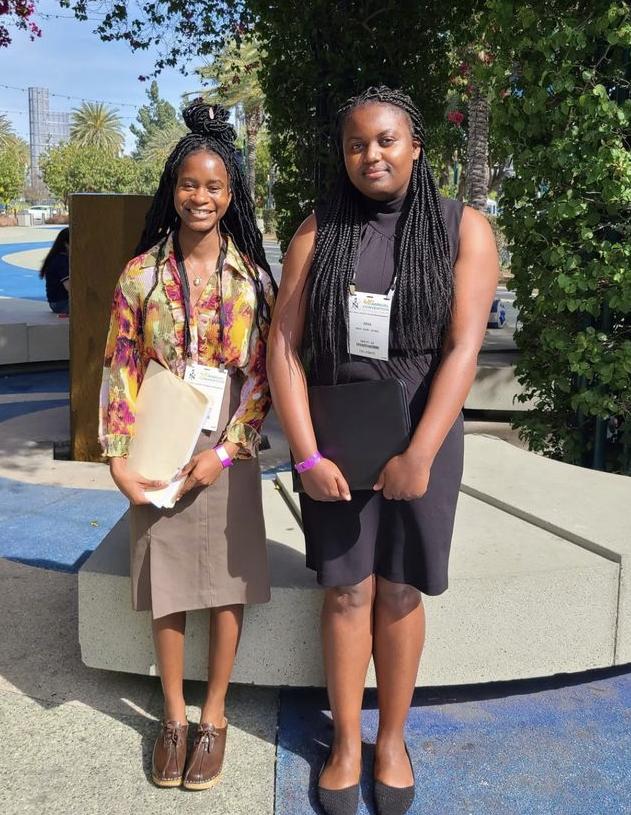 Two female NSBE standing in front of fountain