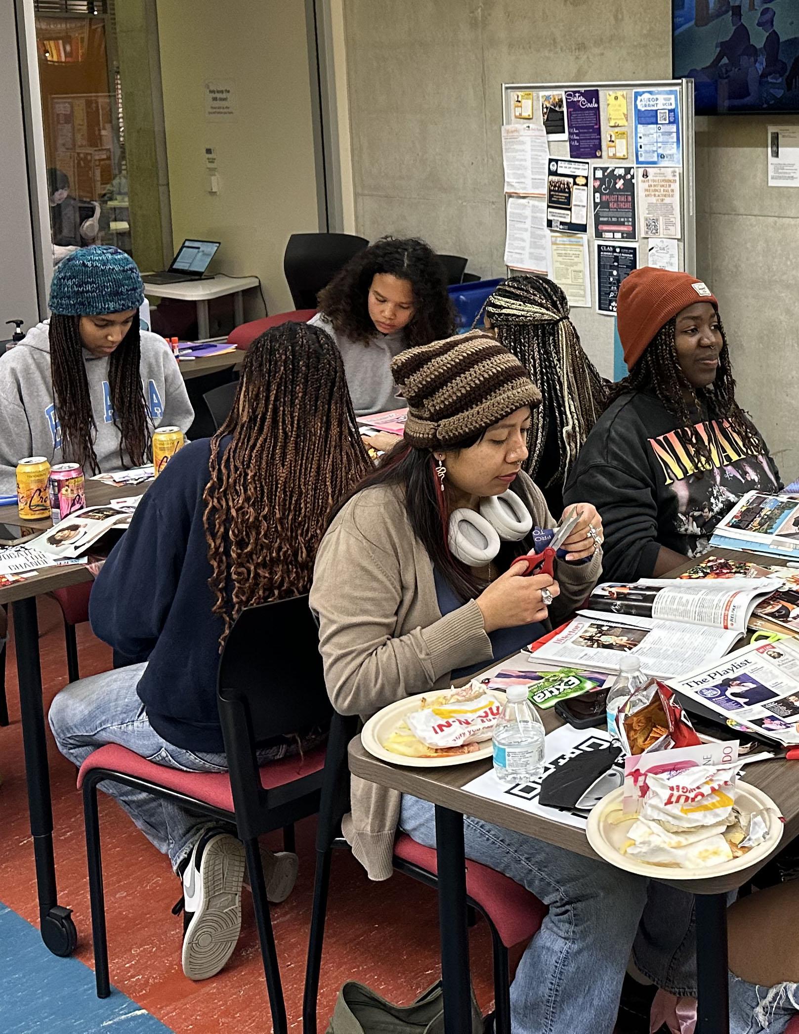 Students sitting at tables creating part of mood board