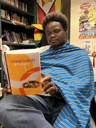 Mhoze Chikowero  reading Apartheid book